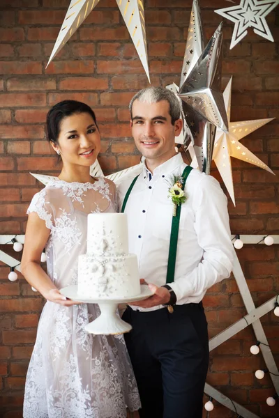 Cheerful married couple standing near the brick wall decorated w — Stock Photo, Image