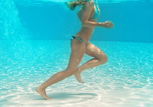 Молодая спортсменка бегает под водой — стоковое фото