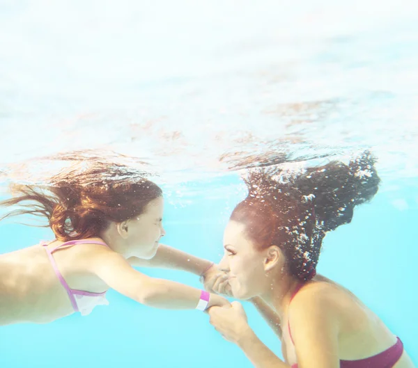 Feliz familia sonriente bajo el agua en la piscina —  Fotos de Stock