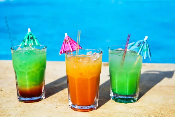 Cocotail drinks by tropical swimming pool — Stock Photo, Image