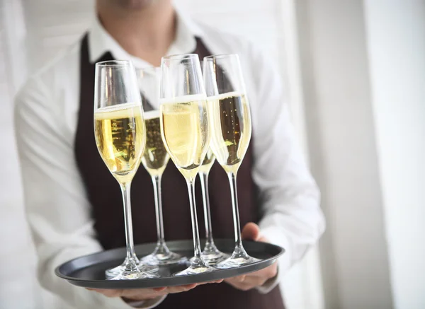 Profesjonalny kelner w mundurze serwujący szampana — Zdjęcie stockowe