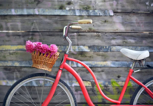 Vintage bicycle with basket with peony flowers — Stock Photo, Image