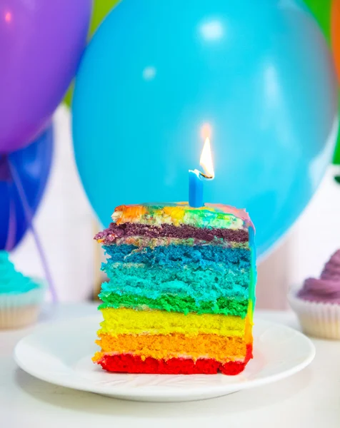 Bolo arco-íris decorado com vela de aniversário — Fotografia de Stock