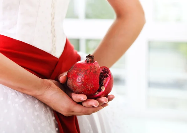 Pomegranat in handen van een bruid — Stockfoto