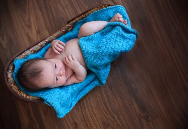 Bébé garçon étendu sur une couverture bleue dans le panier — Photo