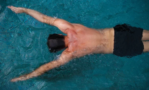 Atletisk man simmar i poolen — Stockfoto