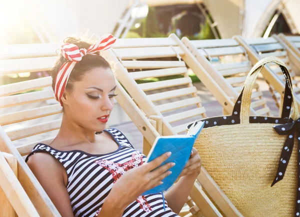 Beautiful pin up girl reading the book near the swimming pool — Stock Photo, Image