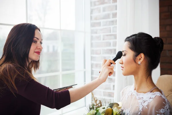 Make-up artist doing make up for young beautiful bride — Stock Photo, Image