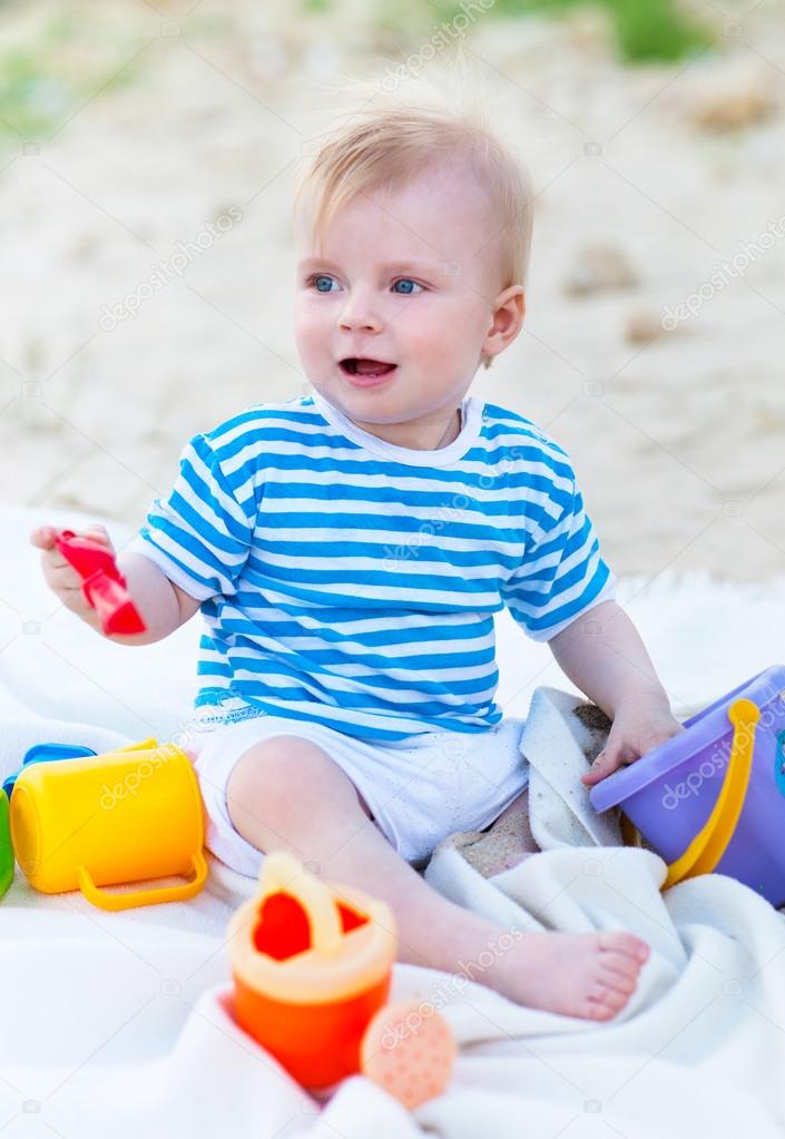 Baby girl playing with beach toys on the beach