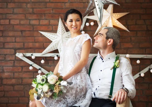 Casal alegre casal de pé perto da parede de tijolo — Fotografia de Stock