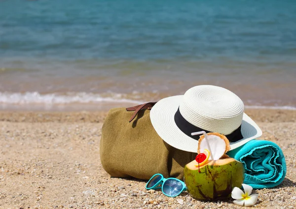 Chapeau de paille, lunettes de soleil, serviette de plage avec sac de plage et noix de coco — Photo