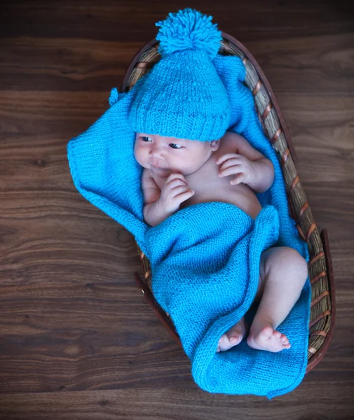 Bébé garçon étendu sur une couverture bleue dans le panier — Photo