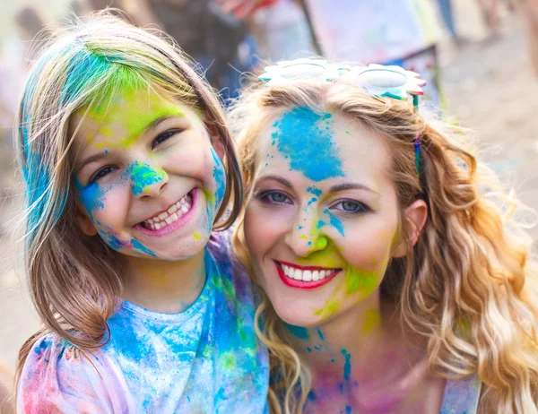 Happy mother with little daughter on holi festival — Stock Photo, Image