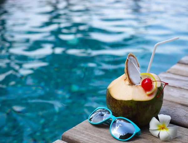 수영장 옆에서 밀짚을 마시는 코코넛 칵테일 — 스톡 사진