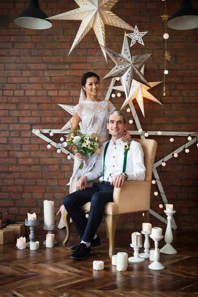 Casal alegre perto da parede de tijolo decorado com as estrelas — Fotografia de Stock