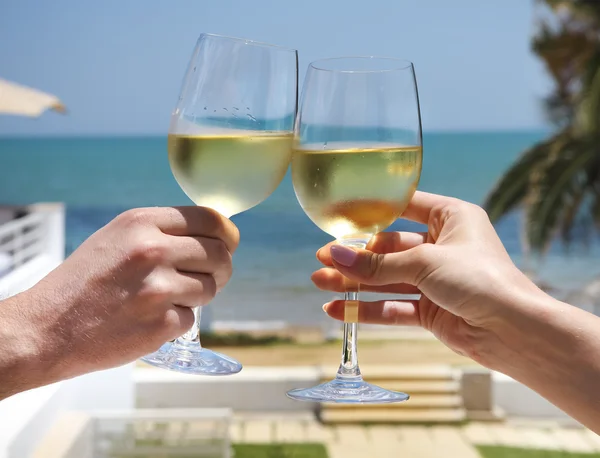 Uomo e donna che battono bicchieri di vino con vino bianco — Foto Stock