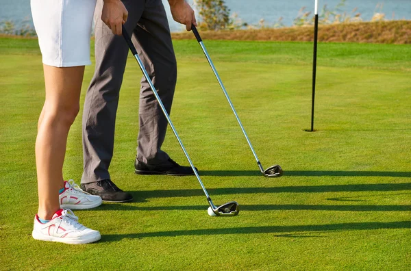 Jong sportief paar golfen op een golfbaan — Stockfoto