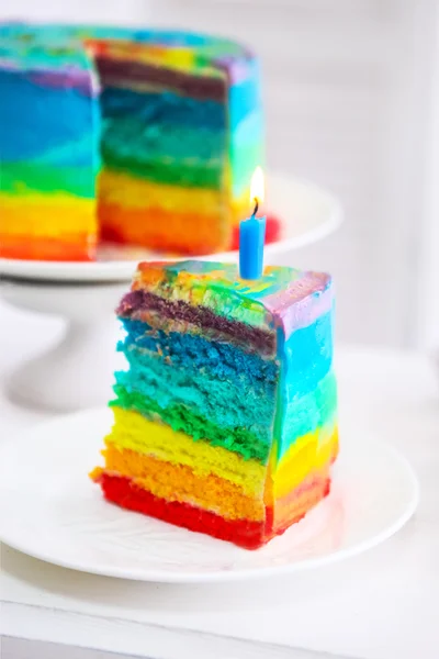 Pastel de arco iris decorado con vela de cumpleaños — Foto de Stock