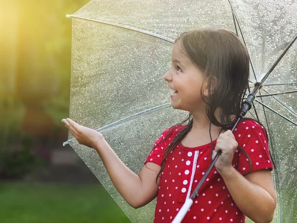 Child wearing polka dots dress under umbrella in rainy day — Stock Photo, Image