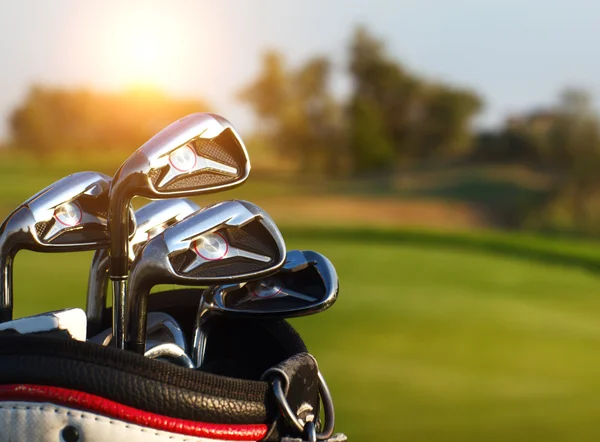 Golf clubs drivers over green field background — Stock Photo, Image