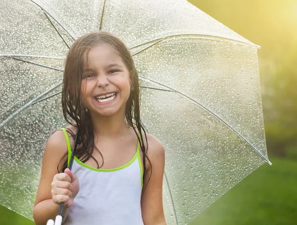 Meisje onder paraplu in regenachtige dag — Stockfoto