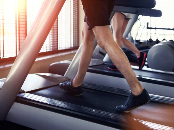 Homme et femme en bonne santé courant sur un tapis roulant — Photo