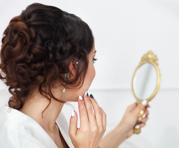 Douce jeune mariée regarde dans le miroir — Photo