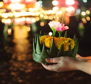 Woman holding kratong in her hands clipart