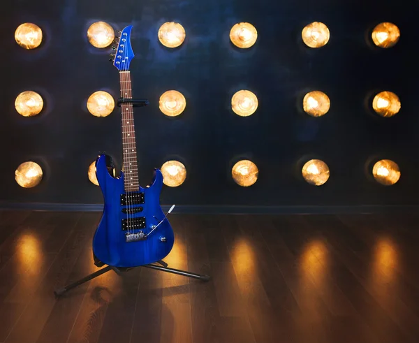 Concepto musical. Guitarra eléctrica de pie en el suelo de madera cerca —  Fotos de Stock