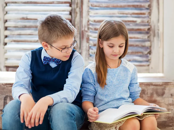 Children reading book in living room — Stock Photo, Image