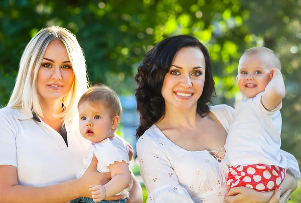 Zwei glückliche Mütter und ihre Babys — Stockfoto