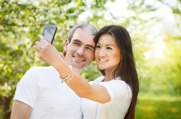 Счастливая пара делает селфи фото на смартфоне на открытом воздухе — стоковое фото