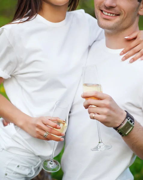 Счастливая улыбающаяся пара пьет шампанское на пикнике — стоковое фото