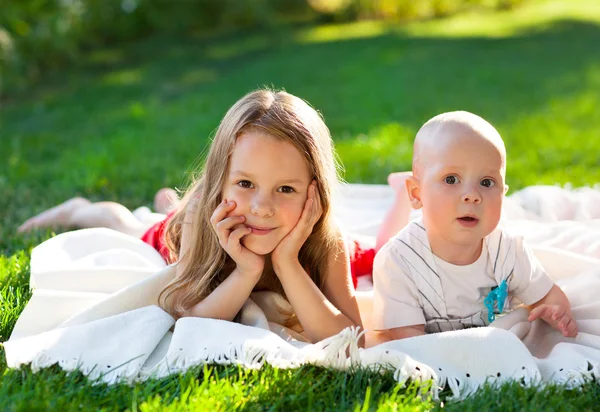 Dos niños en pradera verde y sonríen — Foto de Stock