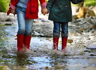 Child wearing rain boots jumping. Close up clipart