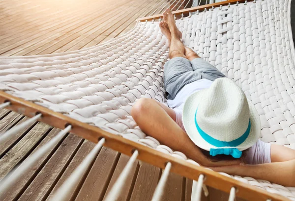 Man in hoed in een hangmat op een zomerdag — Stockfoto