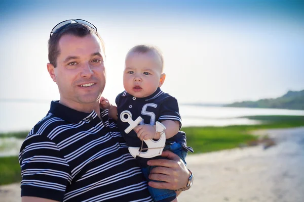 Junger Vater spielt mit Söhnchen wie am Strand — Stockfoto