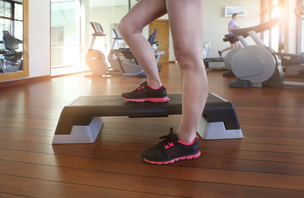 Genç kadın sağlık kulübünde step aerobik yapıyor — Stok fotoğraf