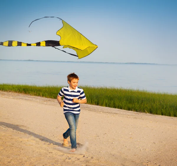 Cute boy running with fly kite beach outdoor — Stock Photo, Image