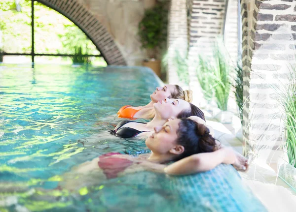 Tres mujeres jóvenes en la piscina — Foto de Stock