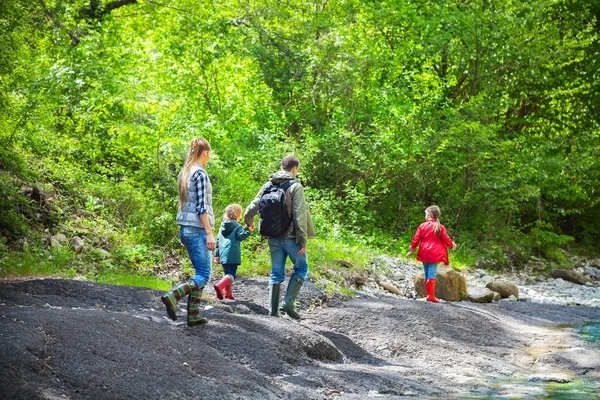 Mutlu genç ailesi ile iki küçük kızı yakınındaki dağ r — Stok fotoğraf