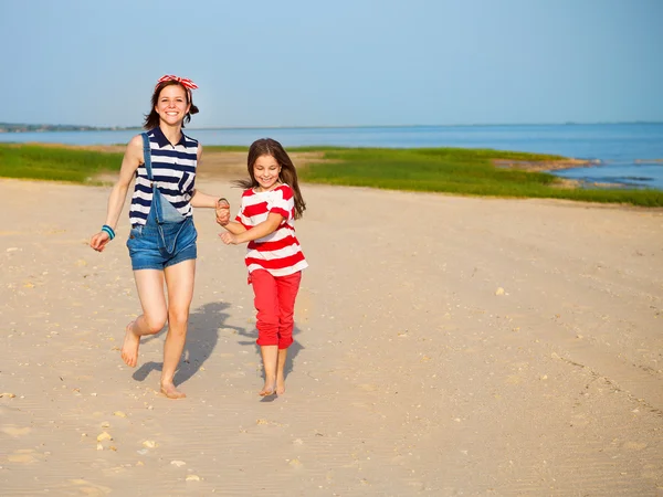 Glada syster spelar på stranden — Stockfoto