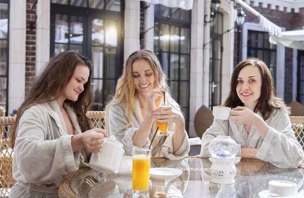 Three young women drinking tea at spa resort — Stock Photo, Image