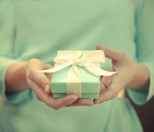 Vrouw met een kleine blauwe doos met een wit lintje — Stockfoto