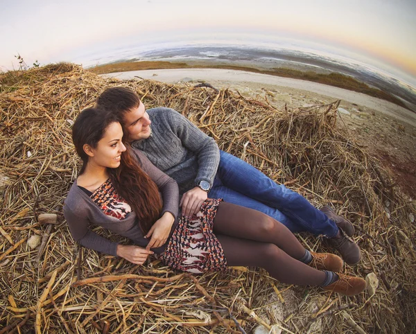 Feliz jovem casal deitado sorrindo no outono fundo — Fotografia de Stock