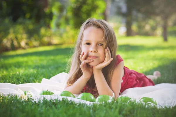 Funny little girl with green apples — Stock Photo, Image