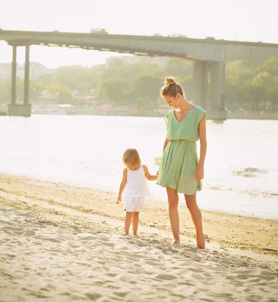 Happy mother with her baby girl at beach at summer — Stock Photo, Image