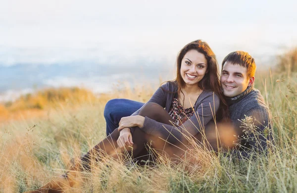 Retrato de jovem casal feliz rindo em um dia frio junto ao mar — Fotografia de Stock