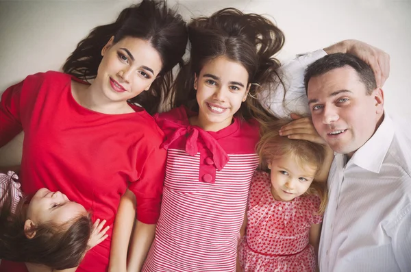 Famiglia giovane felice con bambini che si trovano su un piano — Foto Stock