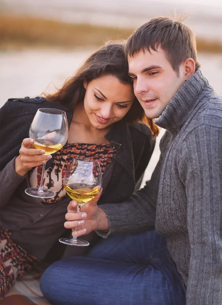 Junges glückliches Paar genießt Picknick mit Weißwein am Strand — Stockfoto